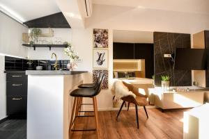 a kitchen with a counter and a stool in a room at Calea Victoriei Modern Studio - Escape in the City Center in Bucharest
