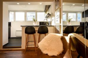 a kitchen with a bar with black stools at Calea Victoriei Modern Studio - Escape in the City Center in Bucharest