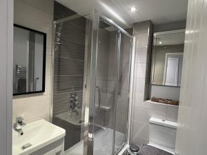 La salle de bains est pourvue d'une douche et d'un lavabo. dans l'établissement Broadway Retreat with free parking, à Herne Bay