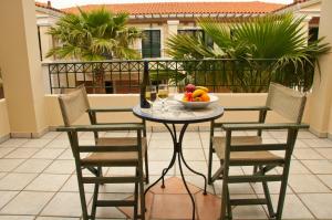 a table with chairs and a bowl of fruit on a balcony at Messina Resort Hotel in Kyparissia