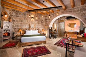 um quarto com uma cama e uma lareira em Dream of Cappadocia em Üçhisar