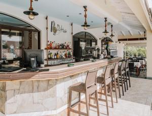a bar in a restaurant with chairs and tables at Maltezos Hotel in Gouvia