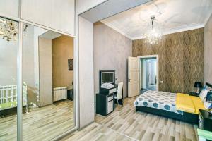 um quarto com uma cama, uma secretária e um espelho em Seaside Apartments em Baku