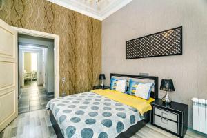 um quarto com uma cama com almofadas amarelas e azuis em Seaside Apartments em Baku