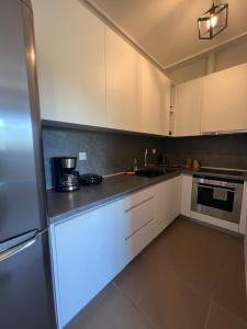 a kitchen with white cabinets and a refrigerator at EVa's Luxury Apartments No 2 in Áyios Spirídhon