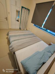 two beds in a room with a window at Master room 1, Couples should be married in Abu Dhabi