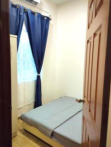 a small bedroom with a bed and a window at Palas Tiny Homestay in Changlun