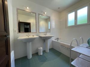 a bathroom with two sinks and a tub and a mirror at Saint marty in Montory +36 photos
