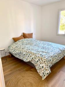 1 dormitorio con 1 cama con edredón de flores en La Bessinoise, 4chambres, Fibre optique et canoe NIORT & BESSINES, en Bessines