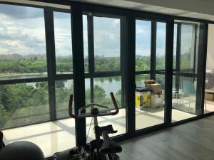 un gimnasio con grandes ventanas y vistas al río en Poseidon Residence, en Bucarest