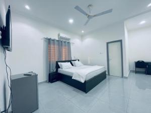 a bedroom with a bed and a ceiling fan at Rakka Guest House in Adentan