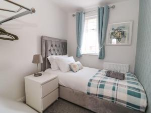 un dormitorio con una cama y una ventana en The Whyte Retreat, en Hornsea