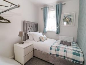 a bedroom with a bed and a window at The Whyte Retreat in Hornsea