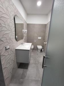La salle de bains est pourvue d'un lavabo et de toilettes. dans l'établissement Home Pacifico, à Vibo Valentia