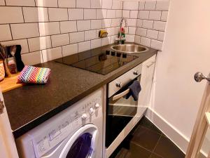 a kitchen with a washing machine and a sink at Shoreditch Private Studio in London