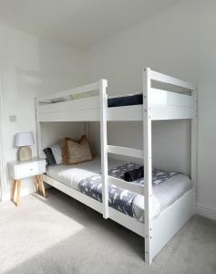 a bedroom with two bunk beds and a lamp at Modern, central bungalow with Luxury Hot tub in Bournemouth