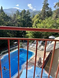 a view from the balcony of a house with a swimming pool at Хотел Костенец in Kostenets