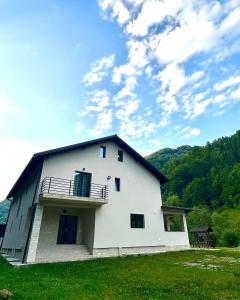 un edificio bianco con balcone sopra di NOR Villa a Ciungetu