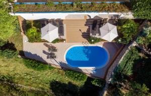 una vista aérea de una casa con piscina y sombrillas en Kuća za odmor VILLA CURLYLOCS - Vila Kosjenka, en Viskovo