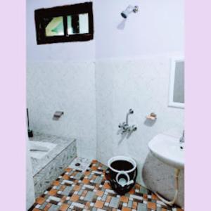 łazienka z umywalką, toaletą i wanną w obiekcie Chawngthu Lodge,Aizawl w Aizawl
