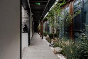 a walkway outside of a building with trees and plants at Jingmao Alley Hotel - Beijing Wangfujing Dongsi Subway Station Branch in Beijing