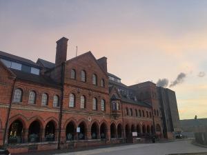 a large red brick building with a lot of windows at Charming 1-Bed Apartment in Newark in Newark-on-Trent