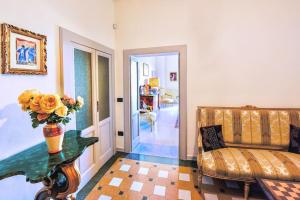 ein Wohnzimmer mit einem Sofa und einer Vase mit Blumen auf dem Tisch in der Unterkunft Grand Horizon Palace - in centro con panorama TOP in Osimo