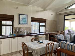 - une cuisine avec une table et des chaises dans la chambre dans l'établissement The Sea Cottage, à Marina Beach