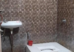 a bathroom with a toilet and a sink at Hotel Basera Odisha in Rourkela