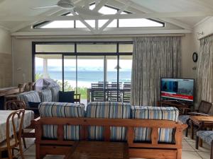 un salon avec canapés et télévision avec vue dans l'établissement The Sea Cottage, à Marina Beach