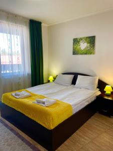 sypialnia z dużym łóżkiem i żółtym kocem w obiekcie Grand Monastery Private Apartments w mieście Pamporowo