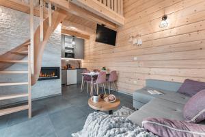 sala de estar con sofá y chimenea en Górski Horyzont - domki nad jeziorem z widokiem na Tatry en Kluszkowce