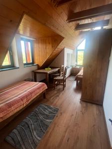 a bedroom with a bed and a desk in a room at Vendégház Petörke in Bárdudvarnok