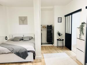 a white bedroom with a bed and a refrigerator at Sublime Appartement 2 pièces au cœur de la Vieille Ville in Nice