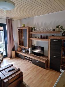 ein Wohnzimmer mit einem Sofa und einem Tisch in der Unterkunft Kleiner Hookie in Hooksiel mit Hund in Wangerland