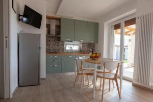 a kitchen with green cabinets and a table and chairs at Casa Valerio in Conversano +57 photos