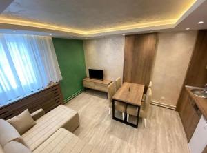 een woonkamer met een bank en een tafel bij MB Apartmani in Kopaonik