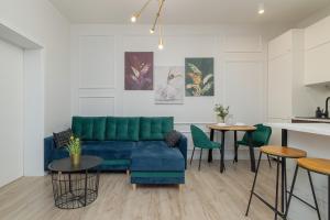 ein Wohnzimmer mit einem blauen Sofa und Tischen in der Unterkunft Kraków Spacious Apartment near Cardiology Clinic by Renters in Krakau
