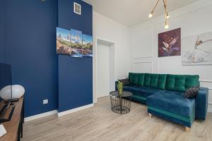 ein Wohnzimmer mit einem blauen Sofa und einem Tisch in der Unterkunft Kraków Spacious Apartment near Cardiology Clinic by Renters in Krakau