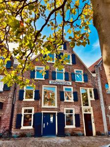 een bakstenen gebouw met blauwe deuren en ramen bij La Dolce Vita Suites in Leeuwarden