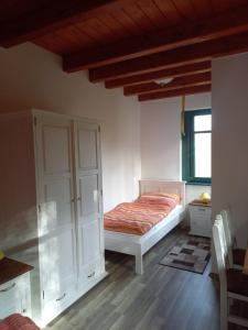 a bedroom with a bed and a white cabinet at Vendégház Petörke in Bárdudvarnok