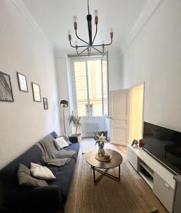 a living room with a blue couch and a table at Sublime Appartement 2 pièces au cœur de la Vieille Ville in Nice