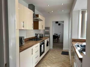 una cucina con armadi bianchi e piano cottura di 74 Ashby House 3 bed townhouse a Brumby