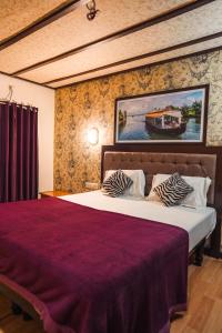 una camera da letto con un letto grande con un dipinto sul muro di Venice Premium Houseboats Alleppey a Alleppey