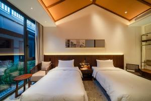 2 Betten in einem Zimmer mit Fenster in der Unterkunft Jingmao Alley Hotel - Beijing Wangfujing Dongsi Subway Station Branch in Peking