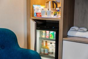 ein Schrank mit Speisen und Getränken in einem Zimmer in der Unterkunft Holiday Inn Hemel Hempstead M1, Jct. 8, an IHG Hotel in Hemel Hempstead