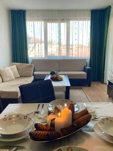 a living room with a table with a candle on it at Grand Monastery Private Apartments in Pamporovo