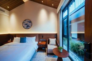 a bedroom with a bed and a chair and a window at Jingmao Alley Hotel Beijing Wangfujing Dongsi Subway Station Branch in Beijing