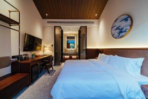 a hotel room with a large bed and a desk at Jingmao Alley Hotel - Beijing Wangfujing Dongsi Subway Station Branch in Beijing