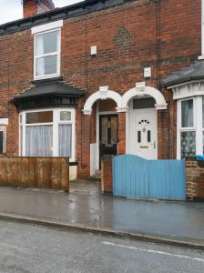 ハルにある3 Bedroom Jesouth Home In Central Hull - Garden- Close to Hull Uniの青い柵のレンガ造りの家